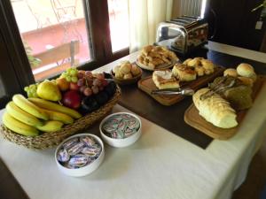 une table recouverte de différents types de pain et de fruits dans l'établissement Las Acacias - Posada de Campo, à Villa General Belgrano