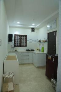 SecunderābādにあるBest place to chill in city! Beautiful 2 BHK Villa!のキッチン(白いカウンター、黒い冷蔵庫付)