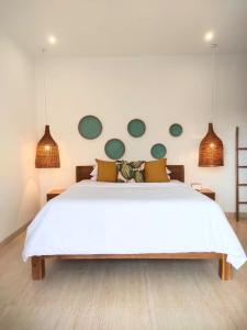 a bedroom with a white bed with green circles on the wall at Arthana Diamond in Nusa Dua +18 photos