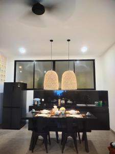 een eetkamer met een zwarte tafel en zwarte stoelen bij Arthana Diamond in Nusa Dua