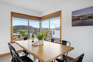 a dining room with a table and chairs and a large window at The Residential Retreat-Sleeps 15-Close to Shops in Warrane