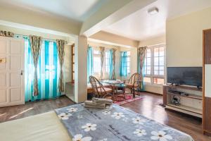 a living room with a table and a television at Little Singamari Home Stay in Darjeeling