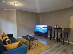 a living room with a blue couch and a flat screen tv at Bördeapartment 2 in Vahldorf +3 photos