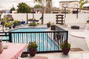 a swimming pool with potted plants on a balcony at Mauya Guesthouse in Kuilsrivier