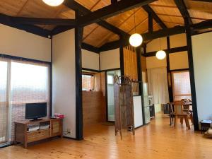 a living room with a television and a wooden floor at 紀州安兵衛 in Kushimoto