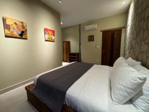 ein Schlafzimmer mit einem großen Bett mit weißer Bettwäsche in der Unterkunft The Cottage Hồ Tràm hills in Thuận Biên