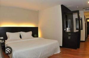 a bedroom with a large white bed and a black cabinet at Reggae Inn in Bintulu