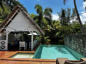 a house with a swimming pool next to a house at Villa Cotzot, 3 chambres, pieds dans l'eau in Poste Lafayette