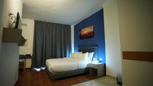 Ένα ή περισσότερα κρεβάτια σε δωμάτιο στο Manara Riva Suites