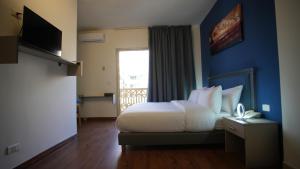 Ένα ή περισσότερα κρεβάτια σε δωμάτιο στο Manara Riva Suites