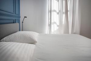a white bed in a room with a window at Appartement entier avec place de parking in Angoulême