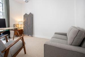 a living room with a couch and a desk at Appartement entier avec place de parking in Angoulême