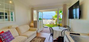 Μια τηλεόραση ή/και κέντρο ψυχαγωγίας στο Direct Beachfront Paradise Retreat - The Coachhouse