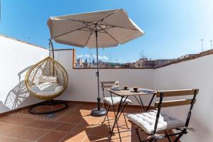 a patio with an umbrella and a table and chairs at Hotel Reina Mora in Granada