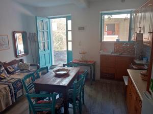 a room with a table and chairs and a kitchen at Παραδοσιακή κατοικία στο κέντρο των Ακουμίων in Akoumia