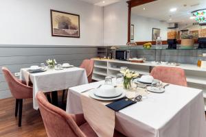 a restaurant with white tables and chairs and a counter at Hotel Reina Mora in Granada