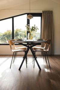 a dining room with a table and chairs and a window at Waterlinie Lodges in Utrecht +58 photos