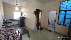 a living room with a couch and a table and a bathroom at Vaidehikunj Homestay in Ayodhya +40 photos