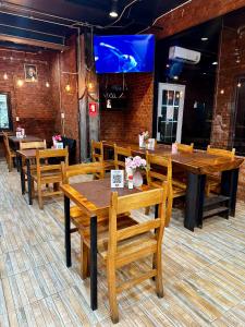 een eetkamer met houten tafels en stoelen bij ZEN Hotel Patong Beach -ex- miami Production in Patong Beach