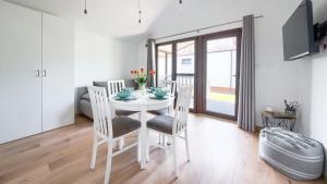 a dining room with a white table and chairs at Zacisze Wrzosowo, Sun & Snow in Wrzosowo