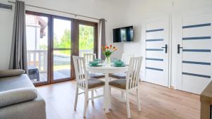 a dining room with a white table and chairs at Zacisze Wrzosowo, Sun & Snow in Wrzosowo