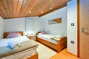 a bedroom with two beds and a wooden ceiling at Vila Ivka Holiday Resort in Donja Poljana +45 photos