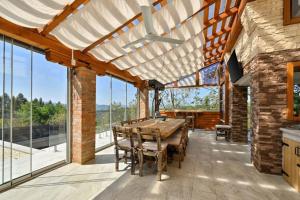 a dining room with a wooden table and some windows at Vila Ivka Holiday Resort in Donja Poljana
