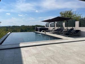 a swimming pool with two chairs and an umbrella at Vila Ivka Holiday Resort in Donja Poljana
