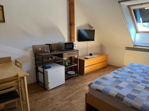 a bedroom with a bed and a desk with a television at Rožmberská Chalupa in Třeboň
