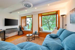 a living room with a blue couch and a flat screen tv at Vila Ivka Holiday Resort in Donja Poljana