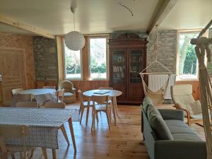a living room with a couch and tables and chairs at Chambre Platane in Cadéac