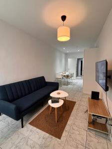 Una sala de estar con un sofá azul y una mesa. en Le pic de Pierreuse, en Lieja