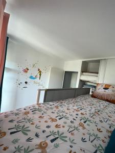 une chambre avec un lit avec un couvre-lit avec des animaux dessus dans l'établissement Apartamento en Val d'erurope, à Chessy