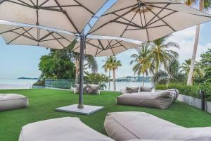 a patio with two couches and an umbrella at Beachfront Luxury Apartment 33 in Bang Rak Beach
