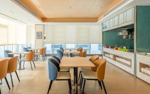 a restaurant with tables and chairs and a kitchen at Holiday Inn Express Binzhou City Center by IHG in Binzhou +44 photos