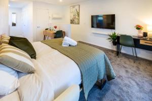 クライストチャーチにあるLuxury Studio With Balcony - Close to Supermarketのベッドとテレビがあるホテルの部屋