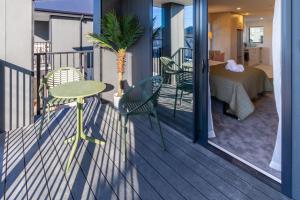 クライストチャーチにあるLuxury Studio With Balcony - Close to Supermarketのバルコニー(テーブル、椅子付)、ベッドルーム1室が備わります。