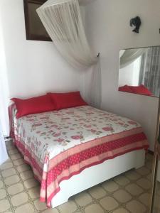 a bedroom with a bed with red pillows and a window at Monolocale a Grado in Grado