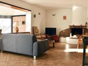 Una sala de estar con un sofá y una chimenea. en Maison de charme avec jardin à Courtils, proche du Mont Saint-Michel, en Courtils