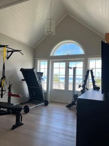 a gym with several tread machines and a window at Villa ved Oslofjorden i Asker in Asker