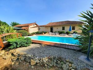 a swimming pool in front of a house at Gîte de Maurin campagne in Marguestau