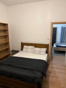 a bedroom with a bed with a black blanket at New flat, own bathroom, sitting room & large bedroom - Walsall in Bescot
