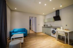 a living room with a blue couch and a kitchen at LACOZi STAY , Seoul in Seoul