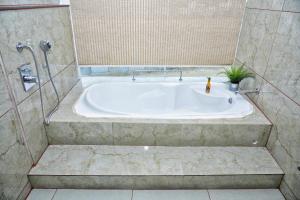 a bath tub in a bathroom with a shower at Vilasini Inn in Maddūr +43 photos