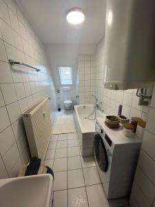 a white bathroom with a sink and a stove at Charmante Altbauwohnung in Erlangen +12 photos