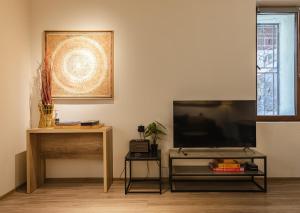 a living room with a flat screen tv and a table at La Maison Mestia in Mestia