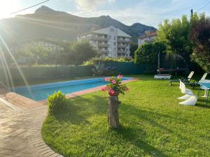 a yard with a pool and a flower pot on a pole at Casa la Choza, con piscina en la playa de Oriñón in Oriñón