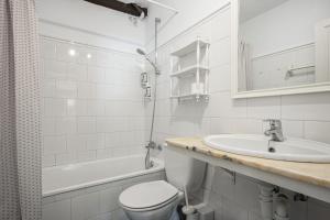 a white bathroom with a toilet and a sink at Apartamento 1 in Selores +15 photos
