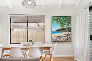 una sala da pranzo con tavolo e sedie di Victor11-Alexandra Headlands Private Oasis ad Alexandra Headland