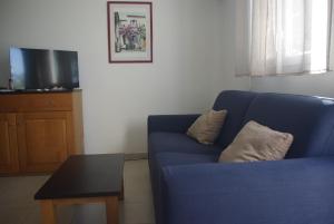 un canapé bleu dans un salon avec une table dans l'établissement Résidence A NUCIOLA Les pieds dans l'eau Cervione Hte CORSE, à Cervione